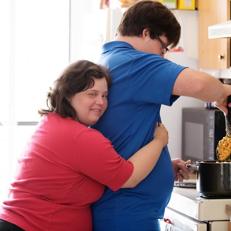 A couple with Down syndrome cooking together. 