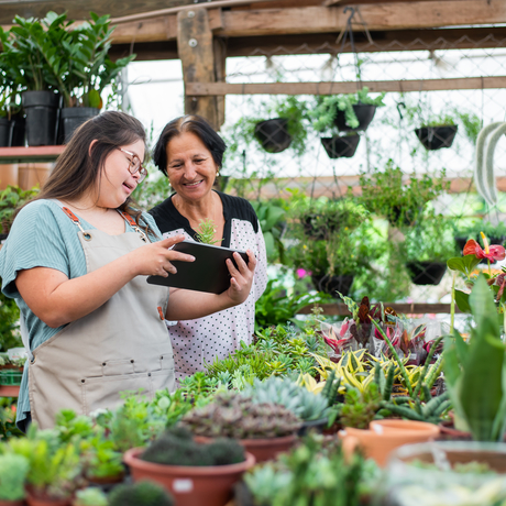 Two florists, one with Down syndrome working in a flower shop.