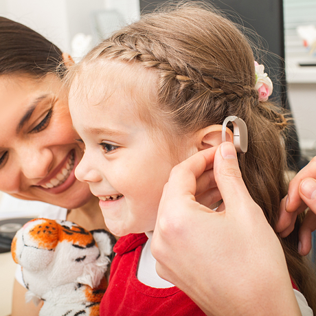 A child patient being fitted for a hearing aid. 