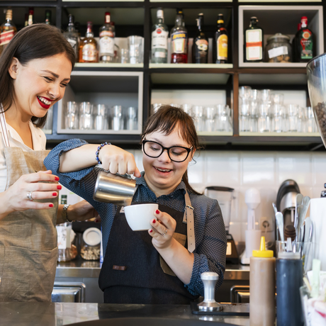 Young woman with Down Syndrome working at cafe.