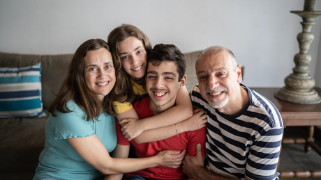 Portrait of a family at home, with their son who has autism.